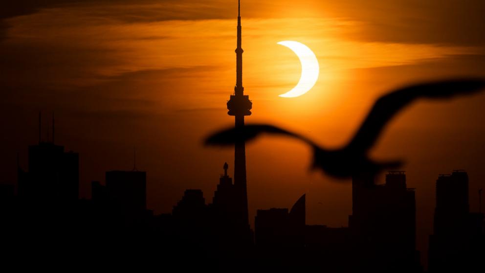 PHOTO: The sun rises behind the skyline during an annular eclipse in Toronto, Canada, June 10, 2021. 