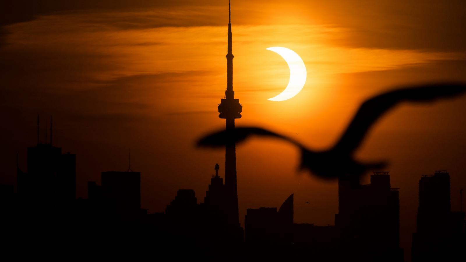 PHOTO: The sun rises behind the skyline during an annular eclipse in Toronto, Canada, June 10, 2021.