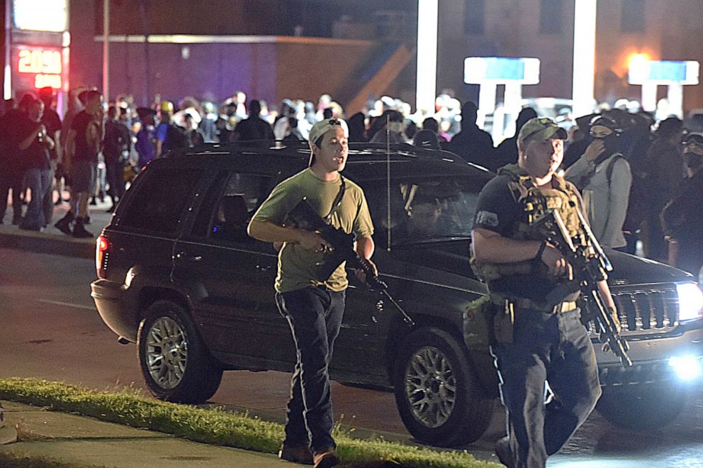 PHOTO: Kyle Rittenhouse, center, with cap on backwards, walks along Sheridan Road in Kenosha, Wis., Aug. 25, 2020, with another armed civilian. 