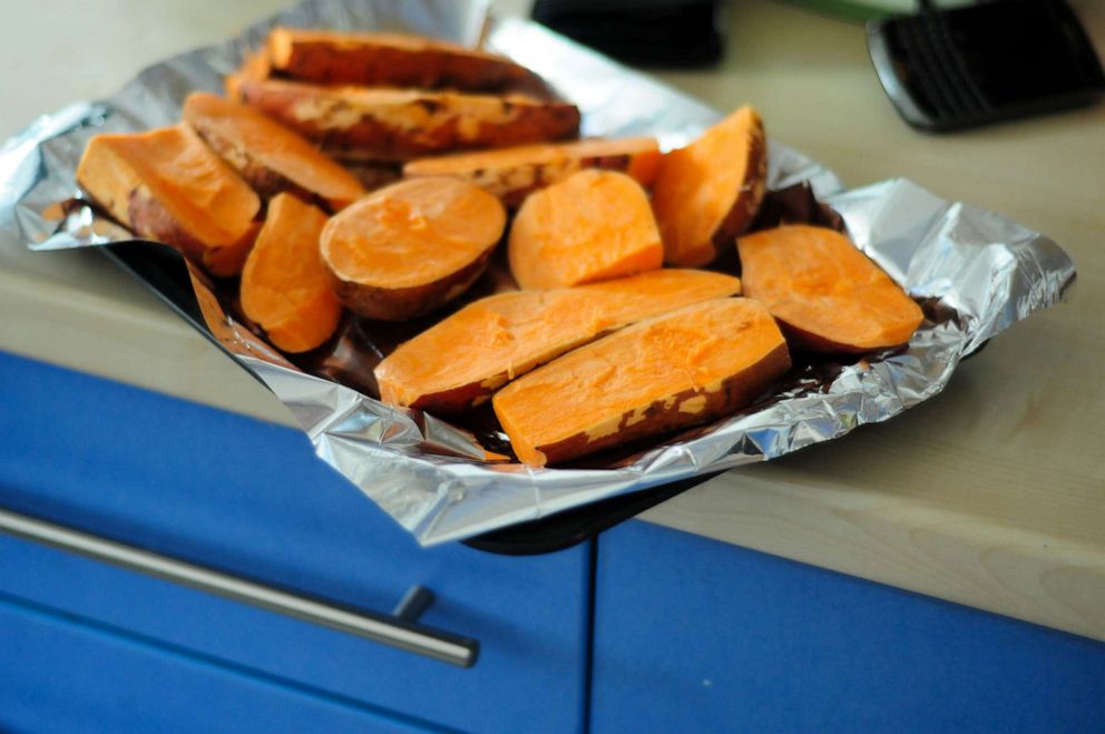 PHOTO: Sliced sweet potatoes are shown on a baking tray lined with tin foil.