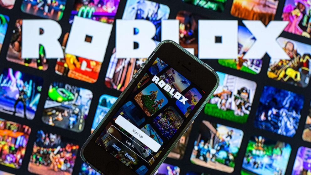 PHOTO: The Roblox app seen displayed on a smartphone screen and a Roblox logo in the background in this photo illustration, March 30, 2021.