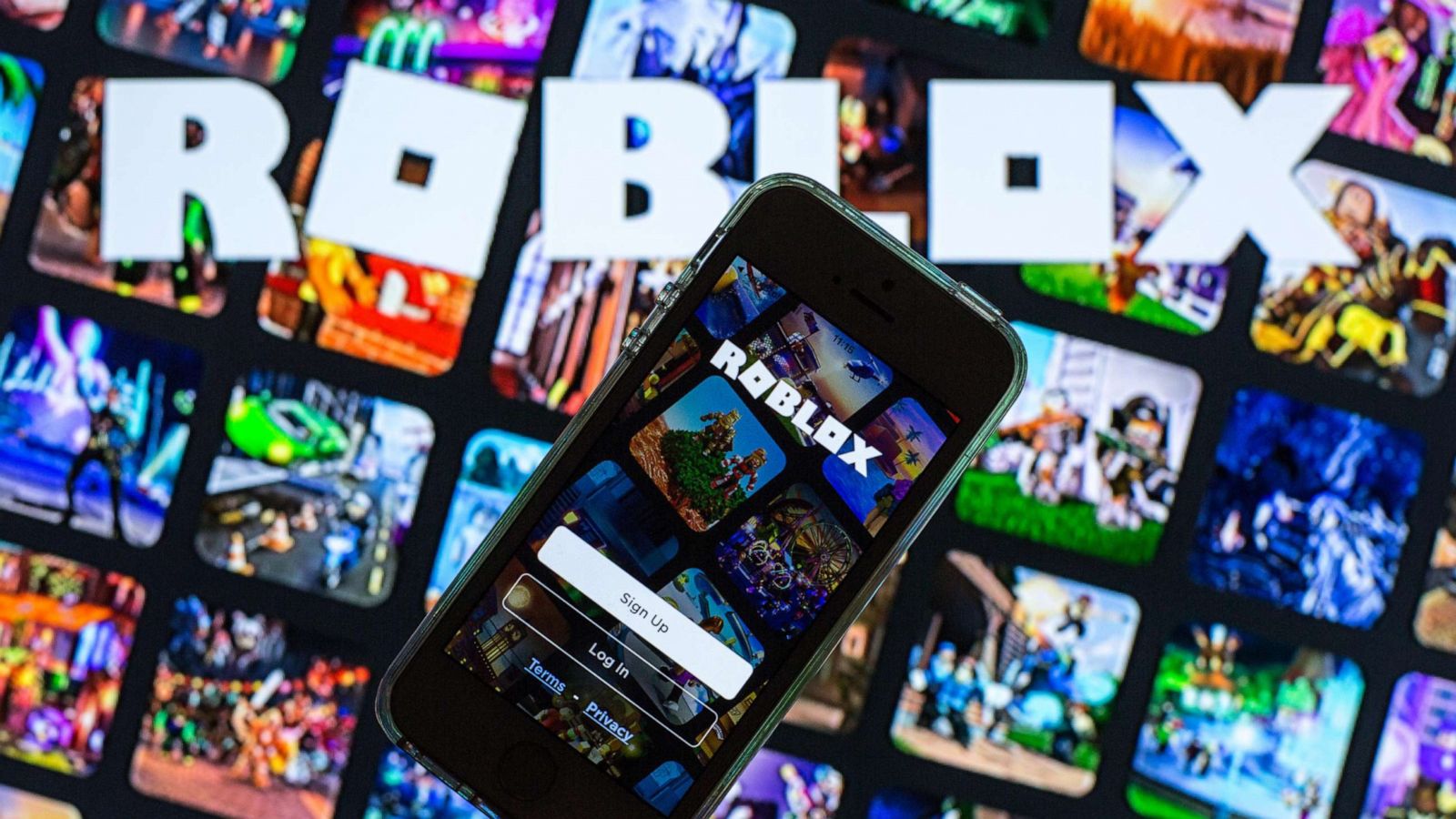 PHOTO: The Roblox app seen displayed on a smartphone screen and a Roblox logo in the background in this photo illustration, March 30, 2021.