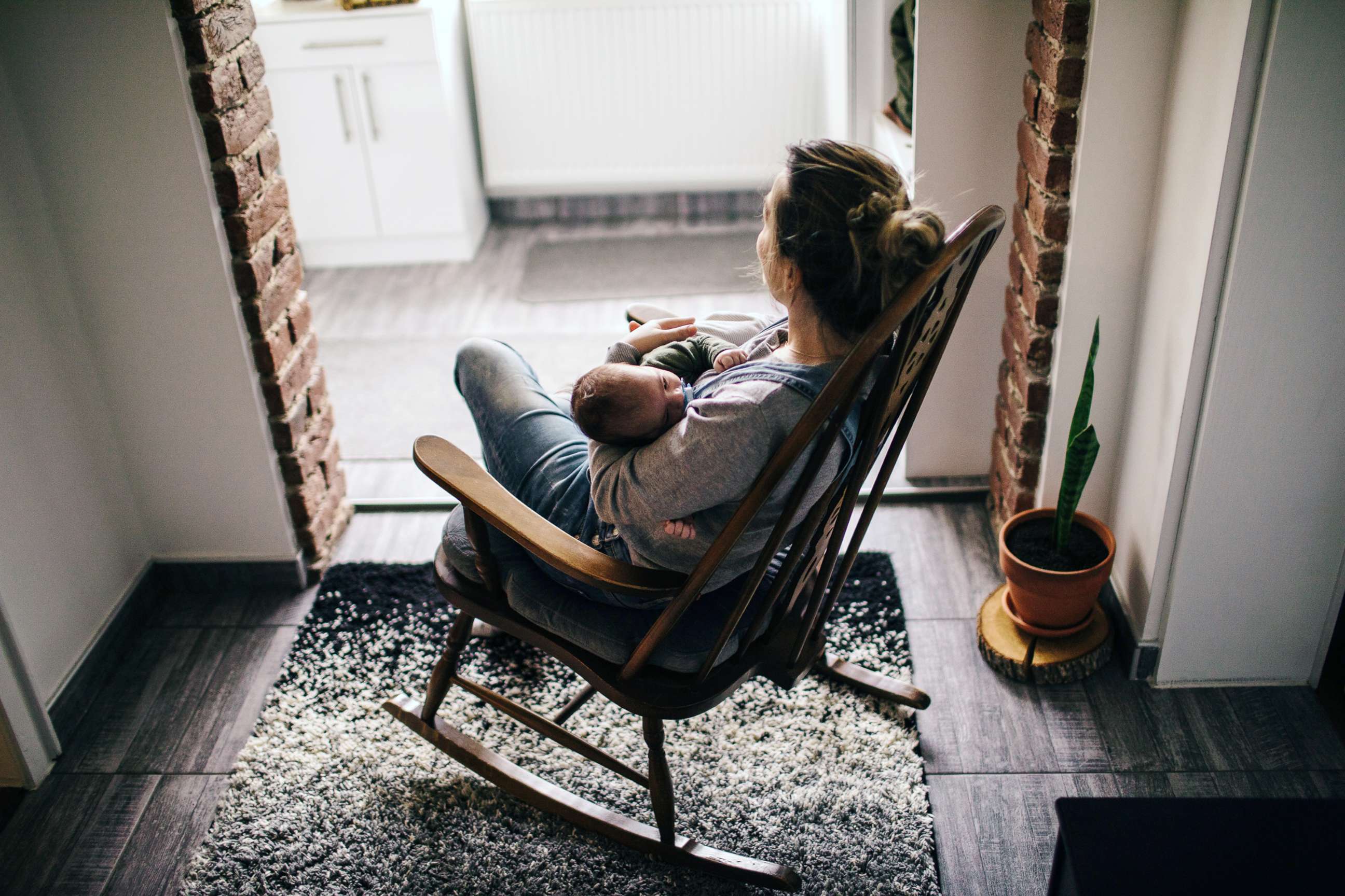 PHOTO: In this undated stock photo, a young mother in a rocking chair rocks her newborn baby to sleep.