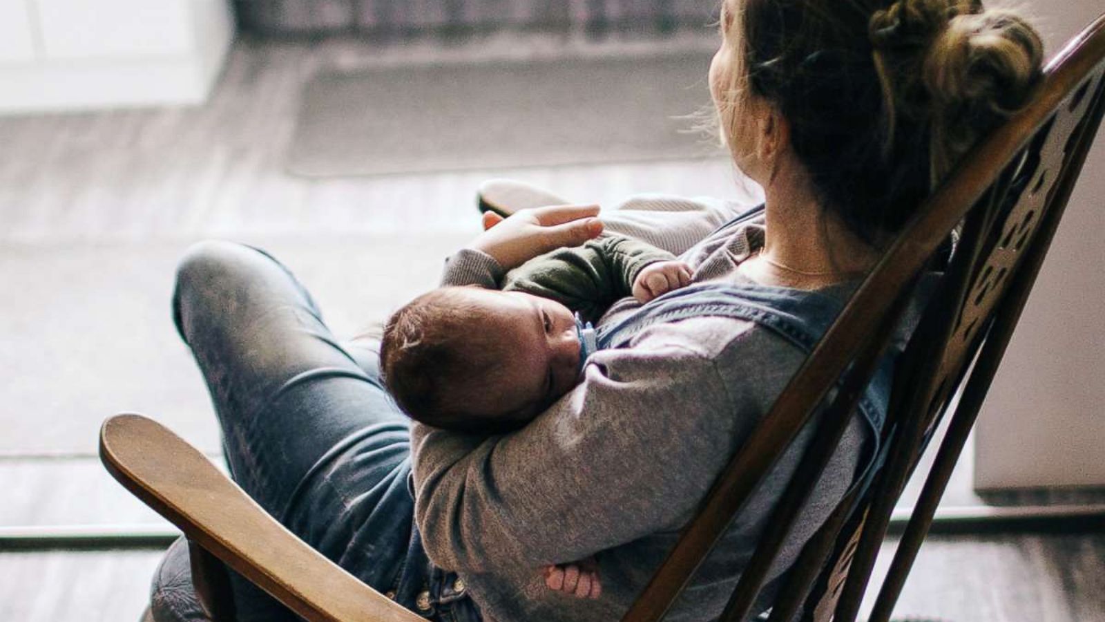 PHOTO: In this undated stock photo, a young mother in a rocking chair rocks her newborn baby to sleep.