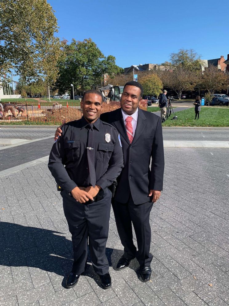 PHOTO: Romar Lyle and his father pose after Lyle's graduation from the police academy.