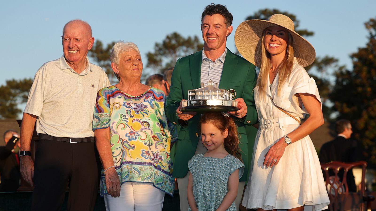 PHOTO: Rory McIlroy of Northern Ireland poses with the Masters trophy alongside father Gerry, mother Rosie, wife Erica and daughter Poppy winning The Masters in Augusta, Georgia, April 12, 2026.