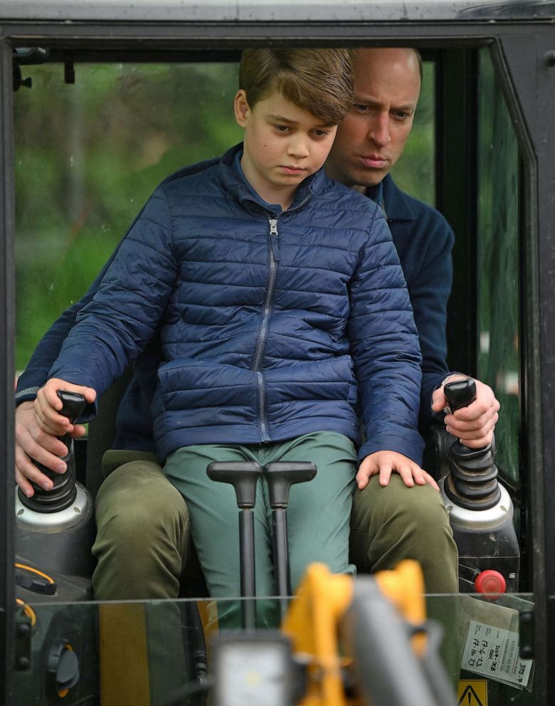 PHOTO: Prince William, Prince of Wales, is helped by Prince George as he uses an excavator while taking part in the Big Help Out, during a visit to the 3rd Upton Scouts Hut in Slough, west of London, May 8, 2023.