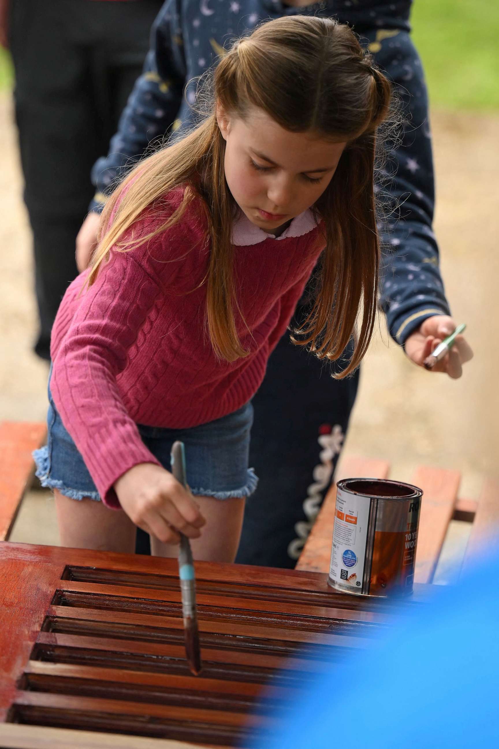 PHOTO: Princess Charlotte of Wales paints some wood while taking part in the Big Help Out, during a visit to the 3rd Upton Scouts Hut in Slough, west of London on May 8, 2023.