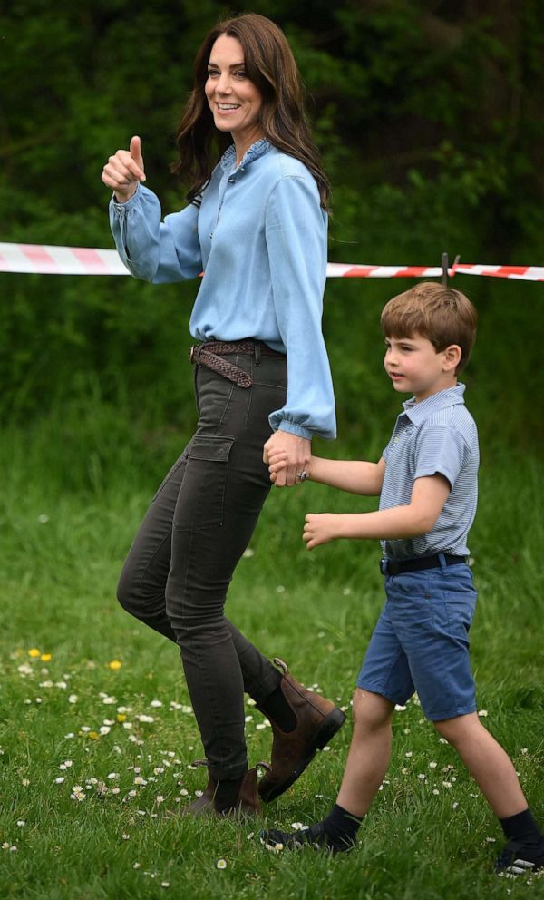 PHOTO: Prince Louis of Wales holds the hand of his mother, Catherine, Princess of Wales (L) while taking part in the Big Help Out, during a visit to the 3rd Upton Scouts Hut in Slough, west of London on May 8, 2023.