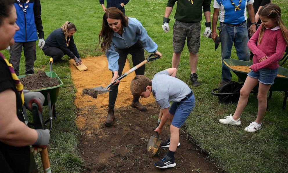 PHOTO: Catherine, Princess of Wales, Prince Louis of Wales and Princess Charlotte of Wales help to reset a path while taking part in the Big Help Out, during a visit to the 3rd Upton Scouts Hut in Slough, west of London on May 8, 2023.