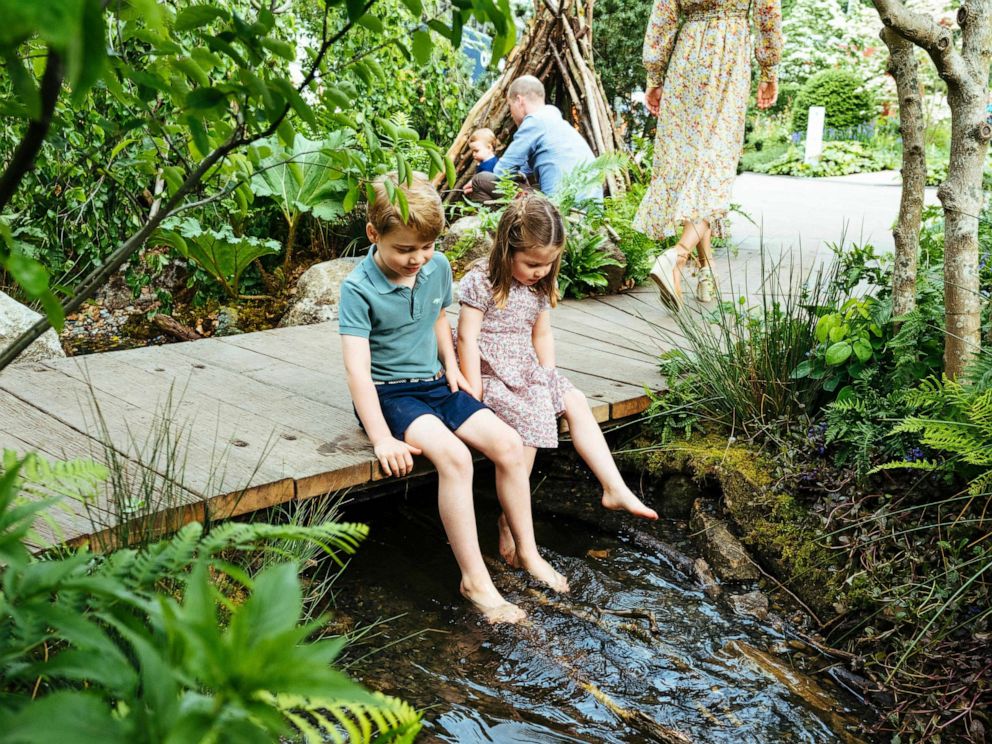 PHOTO: Prince William, Kate, Duchess of Cambridge and their children, Prince George, front, Princess Charlotte, front, and Prince Louis play in the Adam White and Andree Davies co-designed garden, in this image released on May 19, 2019.