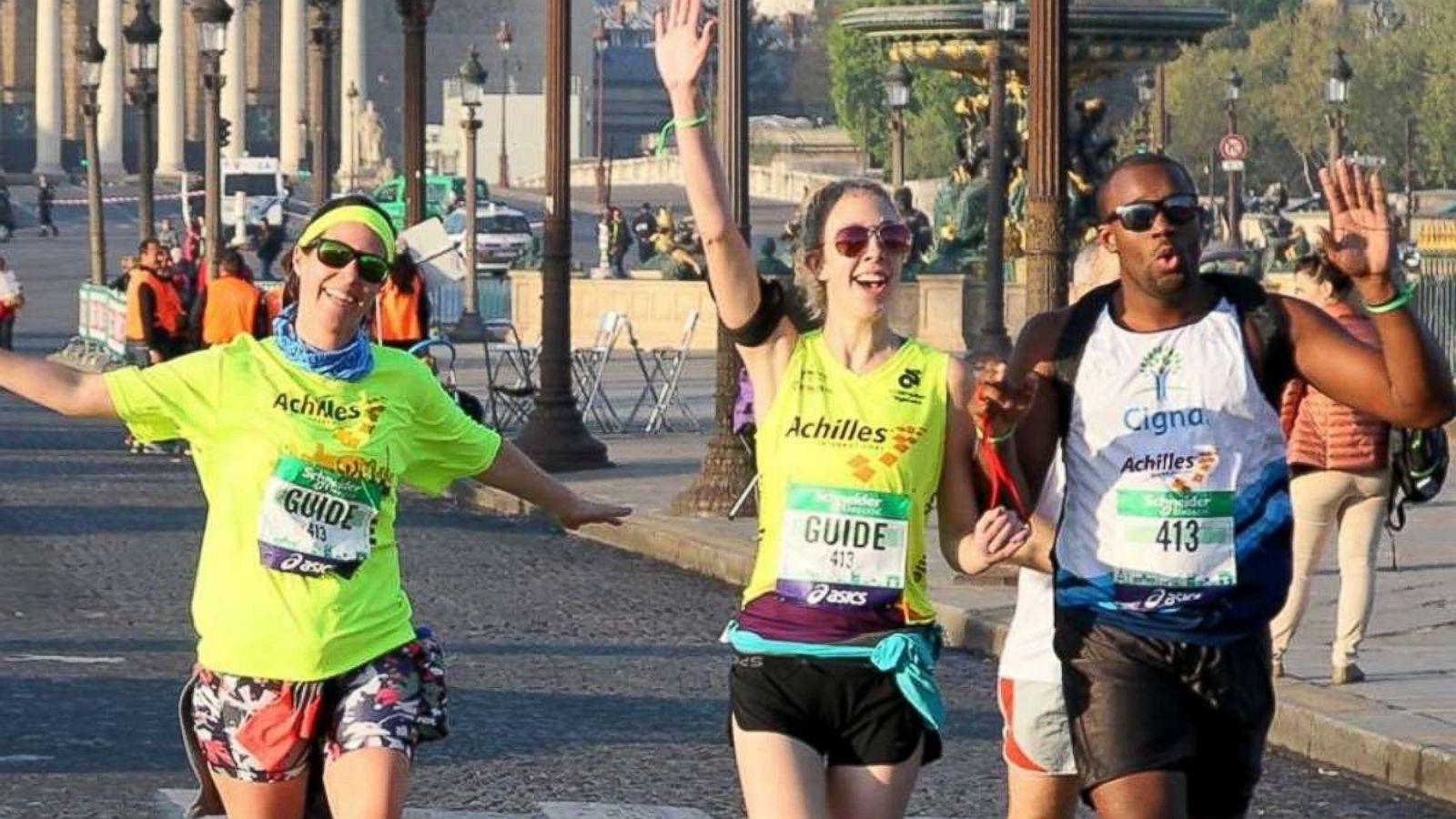 PHOTO: Jessie Rix and Anthony Butler hold up their hands as they run a race together.