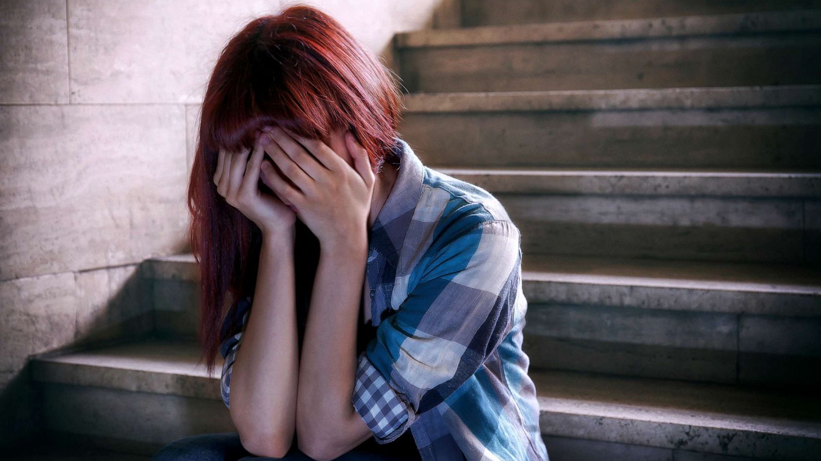 PHOTO: Stock photo of a teen holding their head.