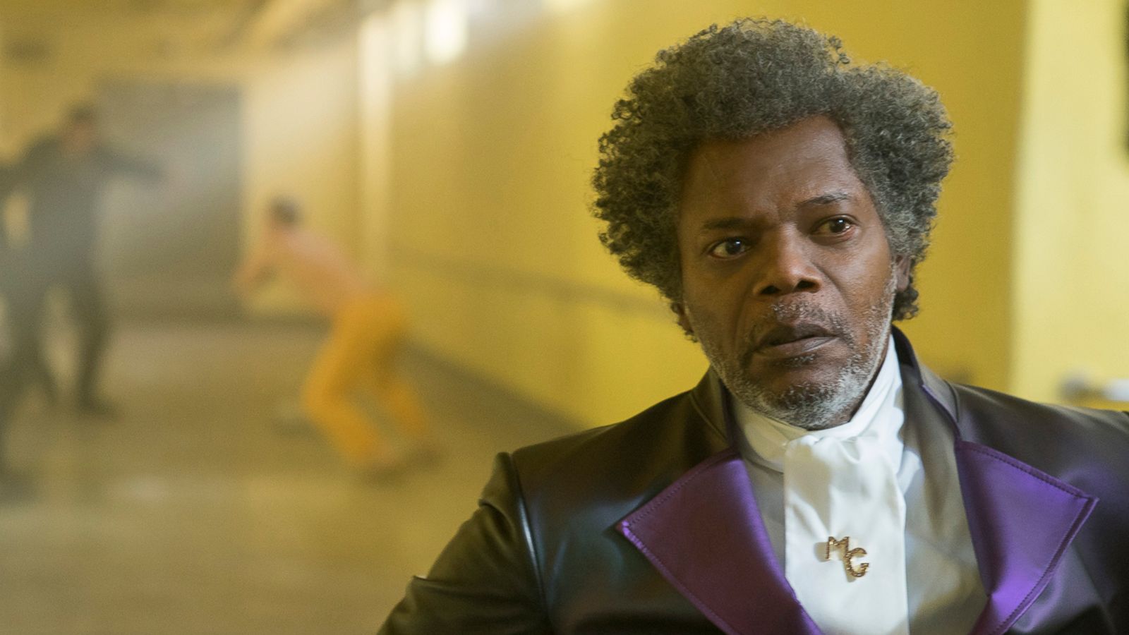 PHOTO: Samuel L. Jackson as Elijah Price/Mr. Glass and James McAvoy (background, in yellow) as Kevin Wendell Crumb/The Horde in "Glass."