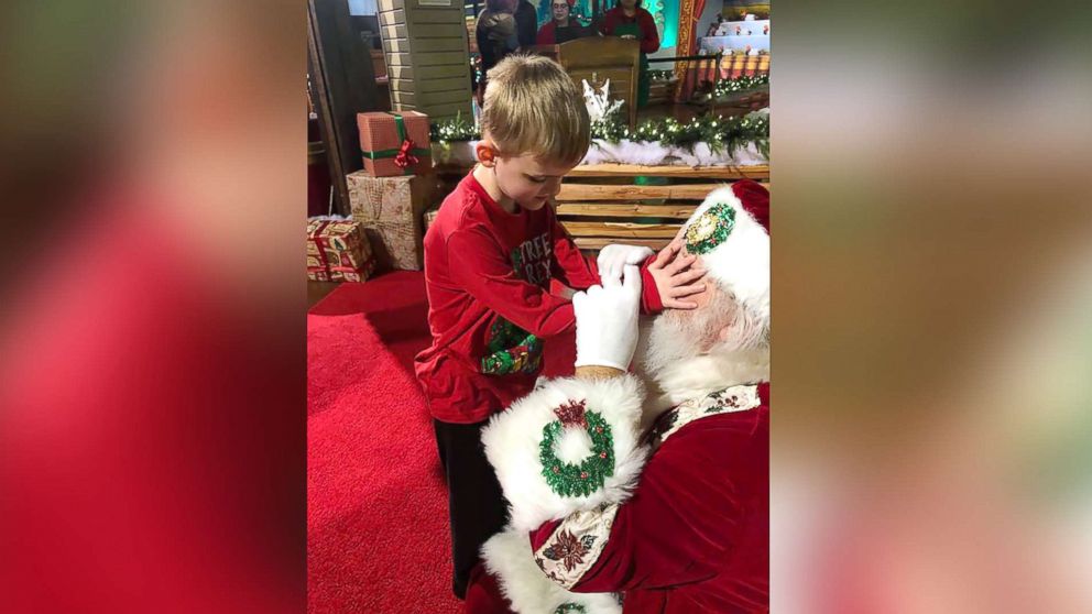 PHOTO: A photo shows Santa Claus allowing Matthew Foster, 6, explore his beard, face, hat and coat.