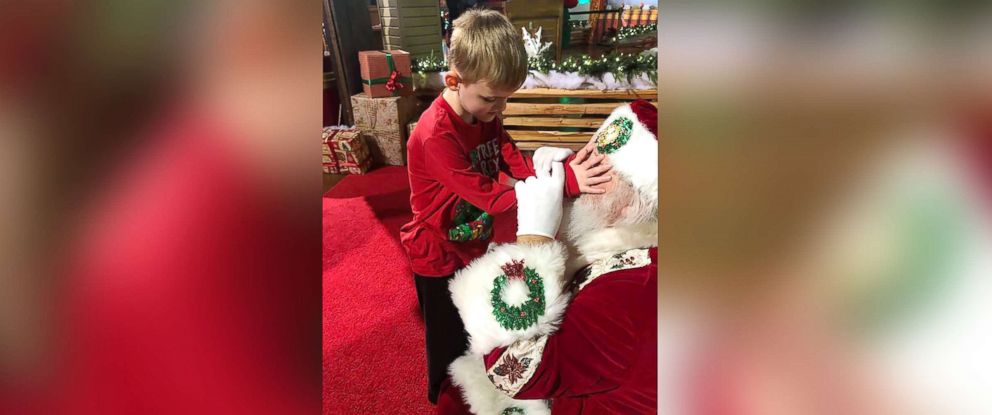 PHOTO: A photo shows Santa Claus allowing Matthew Foster, 6, explore his beard, face, hat and coat.