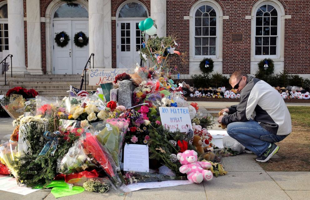 PHOTO: Erik Johannsen of Dover, Maryland, places stuffed animals at a memorial on December 24, 2012, to honor the 26 people killed in the Sandy Hook Elementary School shooting in Newtown, Conn. 