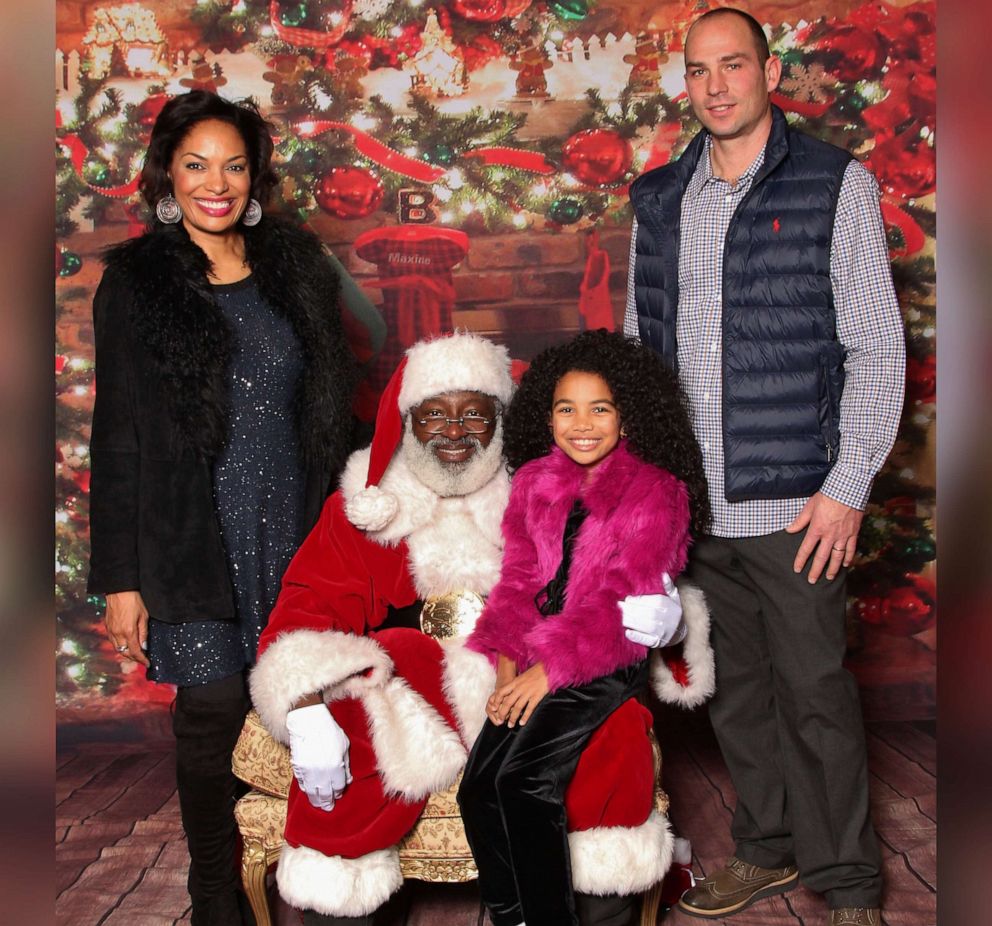 PHOTO: Camille Kauer and her family take a photo with Santa Warren of "Santas Just Like Me" at a festive holiday event.