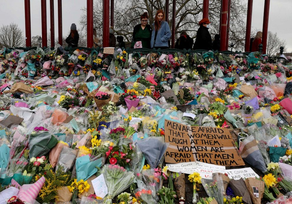 PHOTO: People look at the floral tributes placed in tribute to Sarah Everard on Clapham Common, on March 15, 2021, in London.
