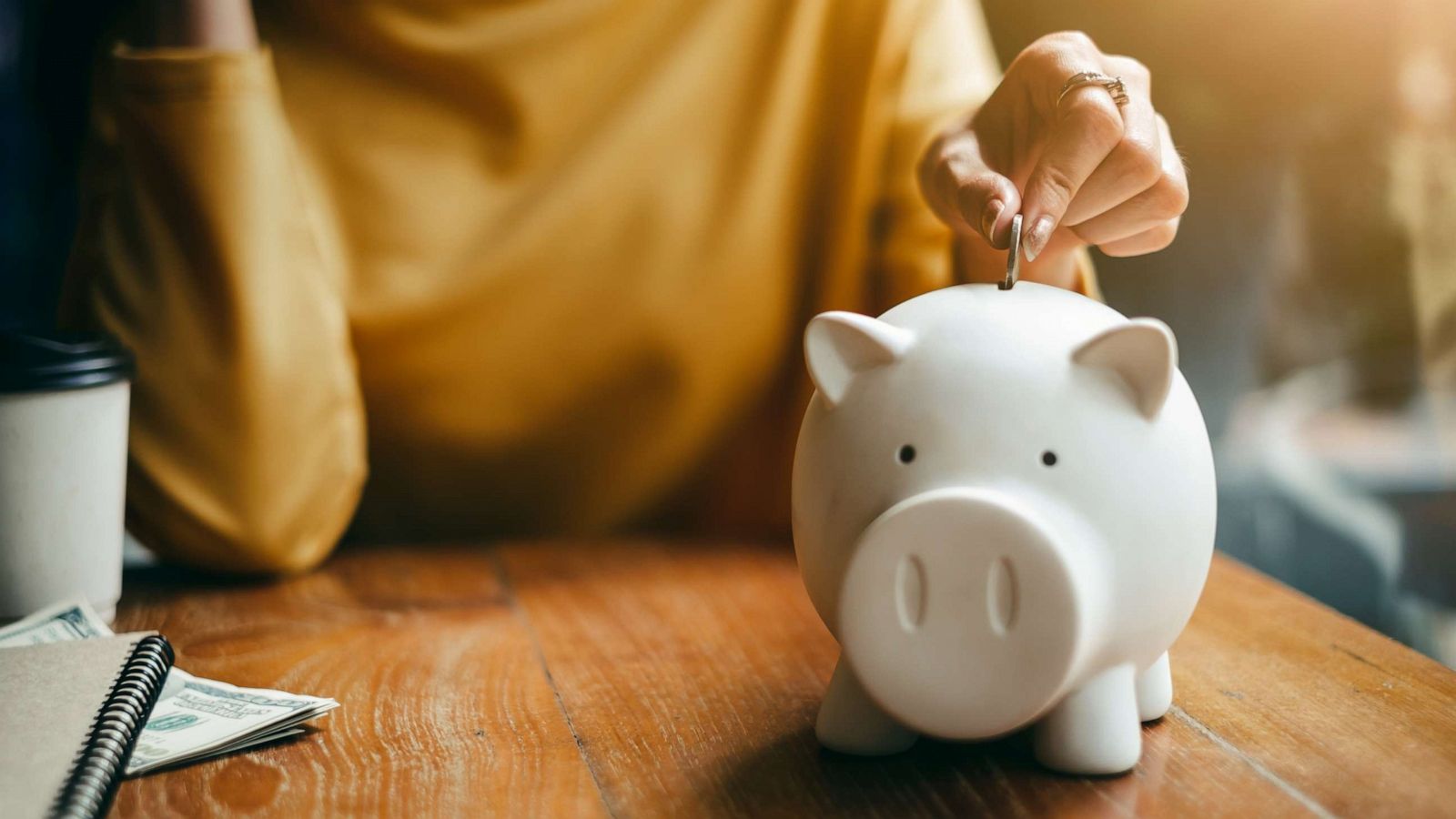 PHOTO: A woman puts change into a bank in this stock photo.