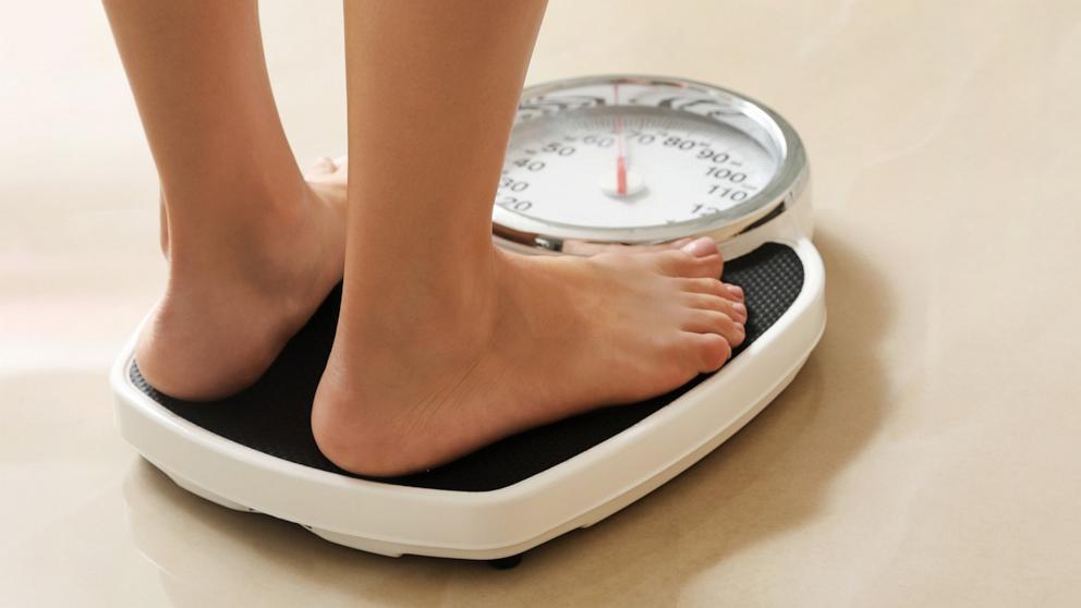 PHOTO: In this undated stock photo, a woman stands on a scale. 