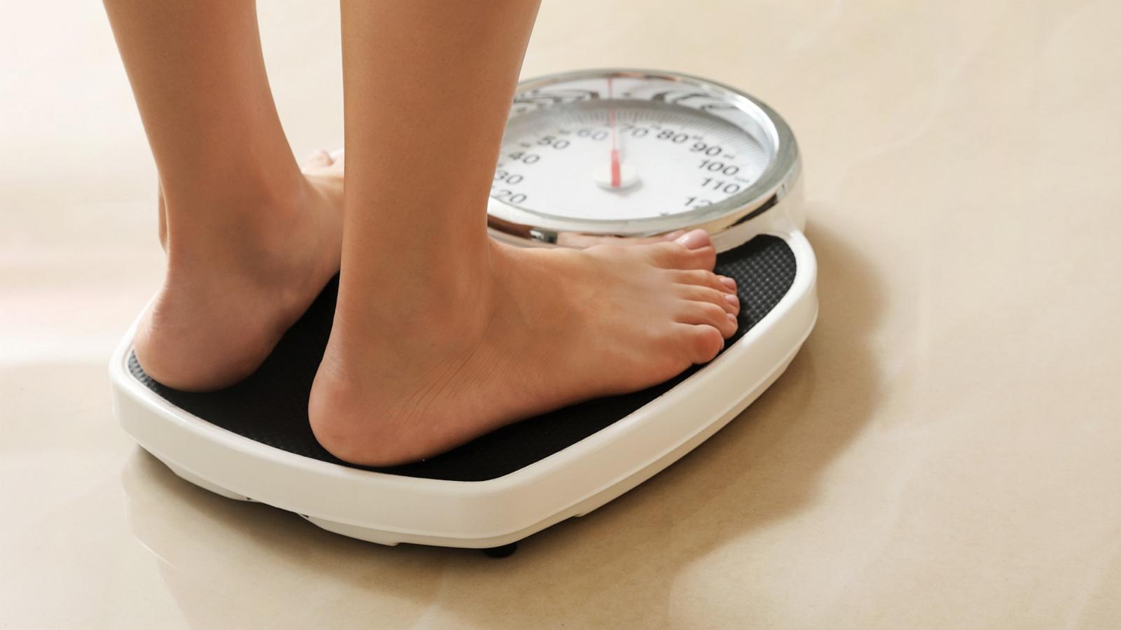 PHOTO: In this undated stock photo, a woman stands on a scale.