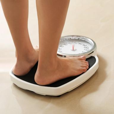 PHOTO: In this undated stock photo, a woman stands on a scale. 