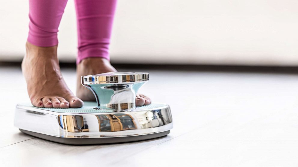 PHOTO: A woman steps on a scale to weigh herself in an undated stock photo.