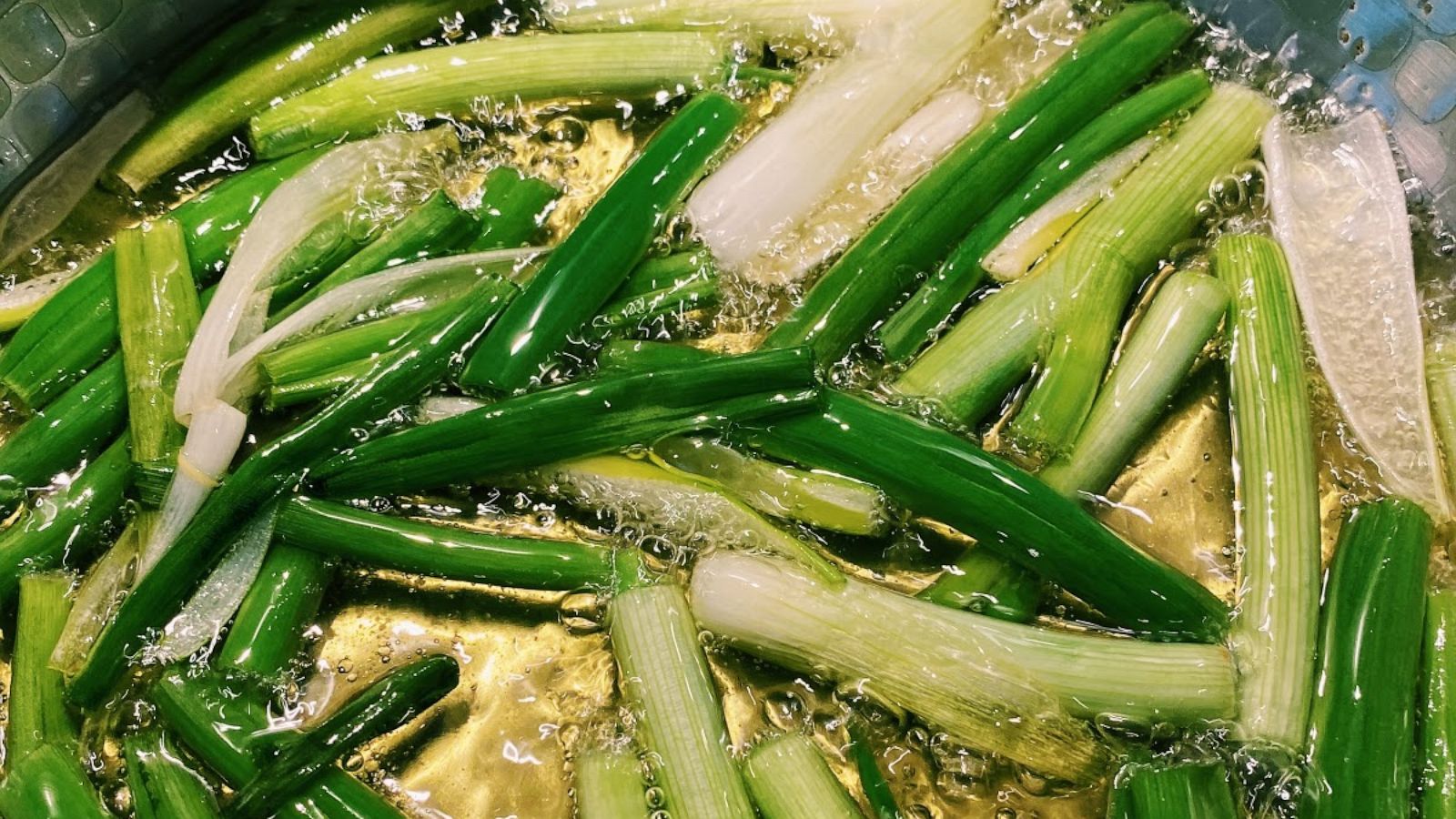 PHOTO: Scallions cook in oil for a homemade Taiwanese noodle dish.