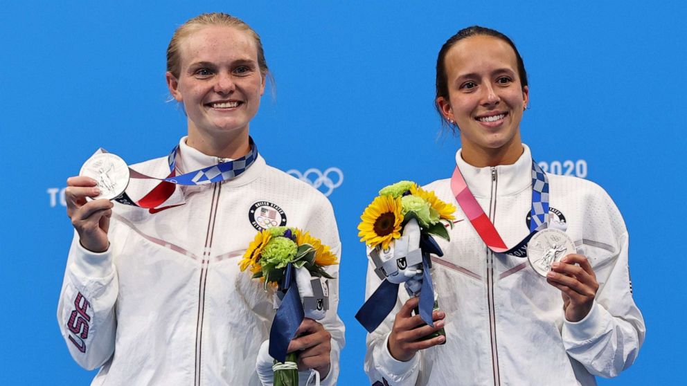 PHOTO: Jessica Parratto and Delaney Schnell of the Untied States pose with their silver medals after the women's 10m platform synchro event at the Olympics in Tokyo, July 27, 2021.
