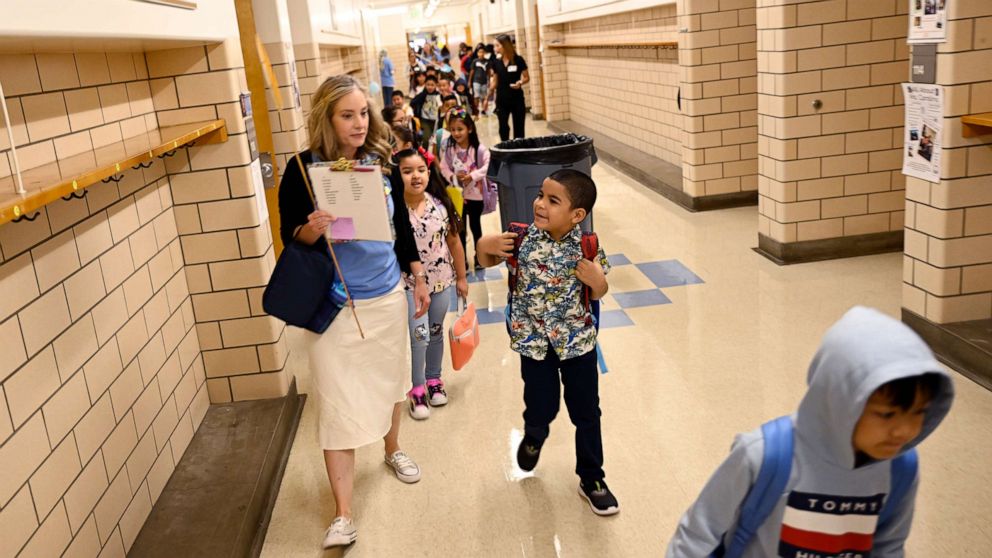 PHOTO: Denver Public School students at Ellis Elementary School follow their 1st grade teacher Megan Westmore to her classroom for the return of the 2022-23 school year, Aug. 22, 2022, in Denver.