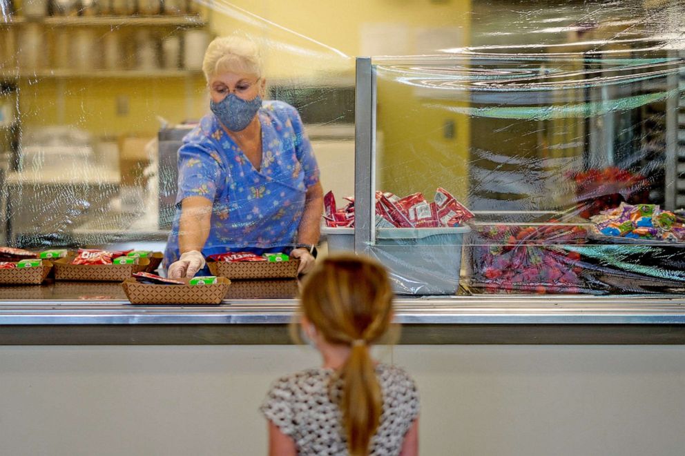 PHOTO: A cafeteria worker passes out lunches at Weaverville Elementary school on Aug. 17, 2020 in Weaverville, Calif. 