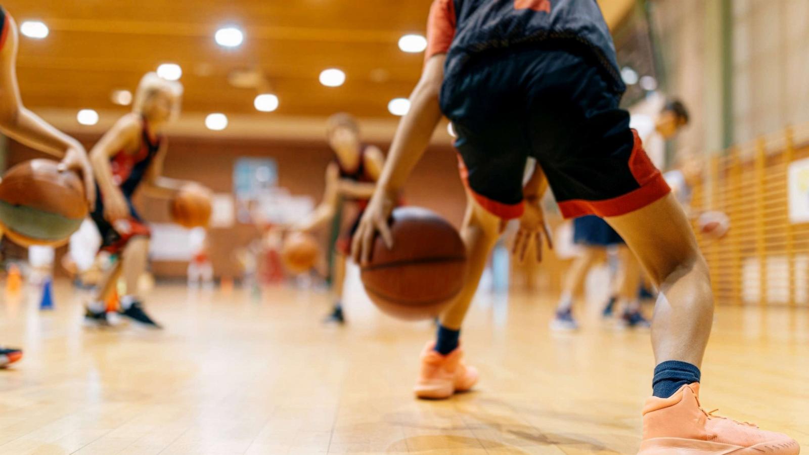 PHOTO: Stock photo of kids playing basketball in school.