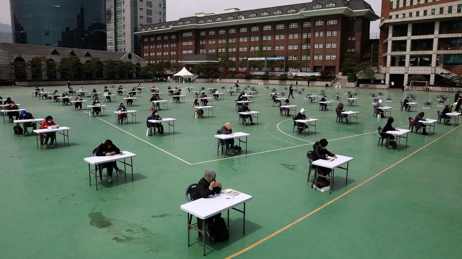 PHOTO: South Koreans wear masks and sit according to social distancing as a preventive measure against the coronavirus at Seokyeong University playground on April 25, 2020 in Seoul.