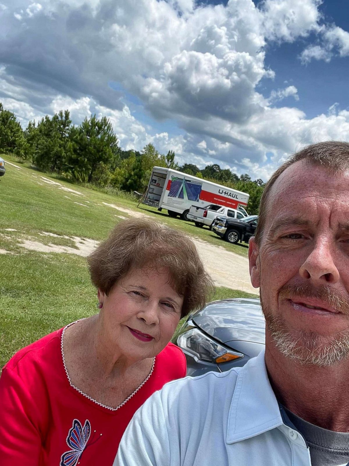 PHOTO: Sean Peacock stands with his mom in front of the U-haul truck in Eastman, Georgia, that will carry the 21 memorial benches to Uvalde, Texas.