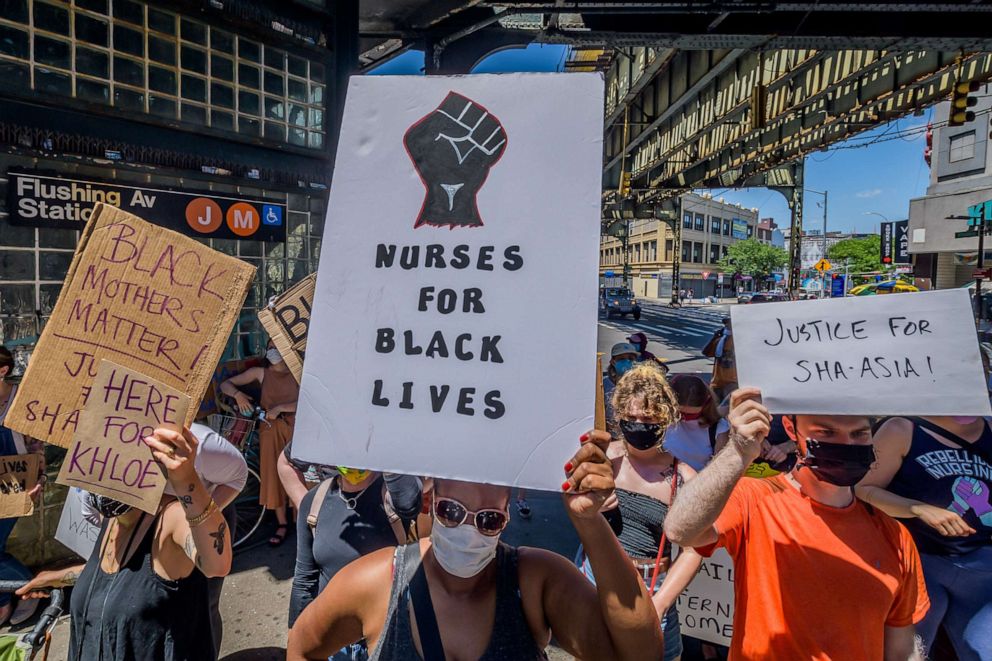 PHOTO: Participant hold signs at a rally to demand justice after Sha-Asia Washington's death while giving birth at Woodhull Medical Center in Brooklyn, New York, July 9, 2020.