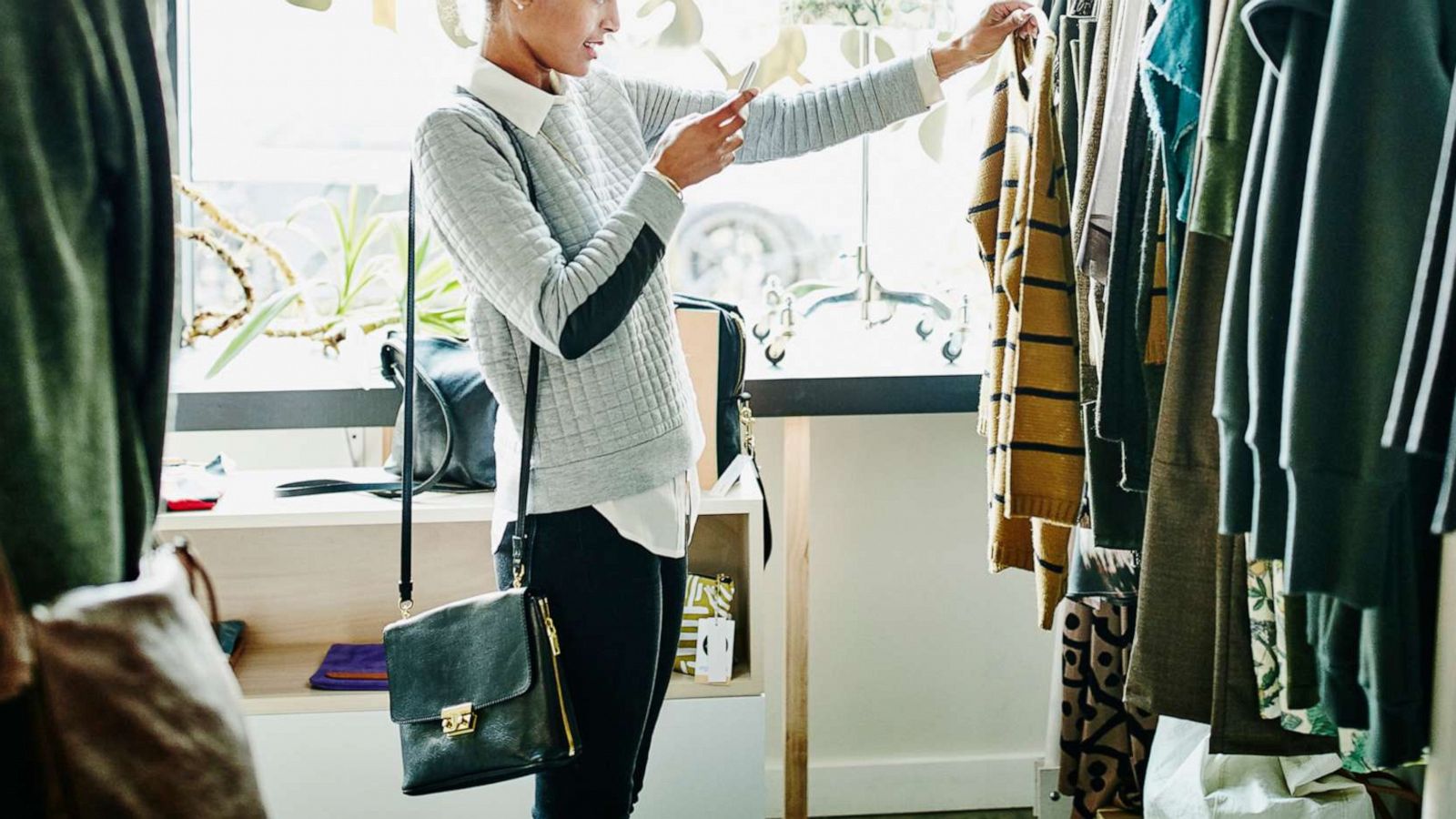 PHOTO: A woman taking photo of clothing with smartphone while shopping in boutique shop in undated stock photo.