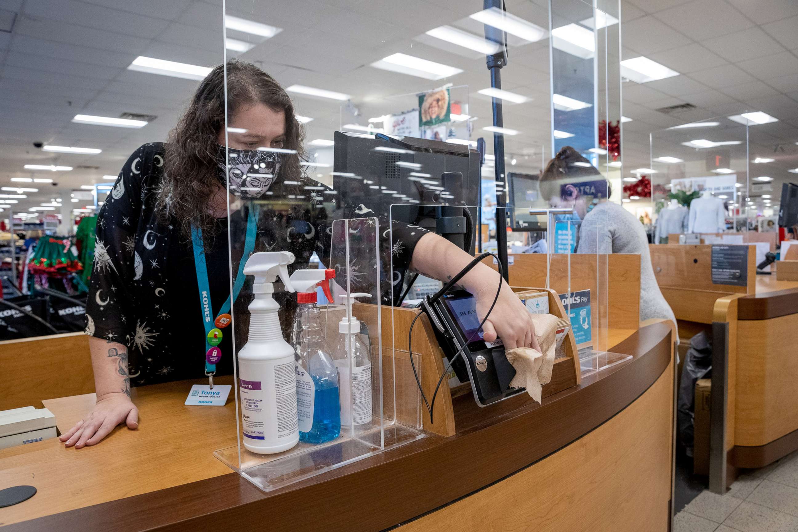 PHOTO: An employee wearing a protective mask disinfects the credit card reader at a checkout counter at a Kohl's department store in Woodstock, Ga., Nov. 23, 2020. 
