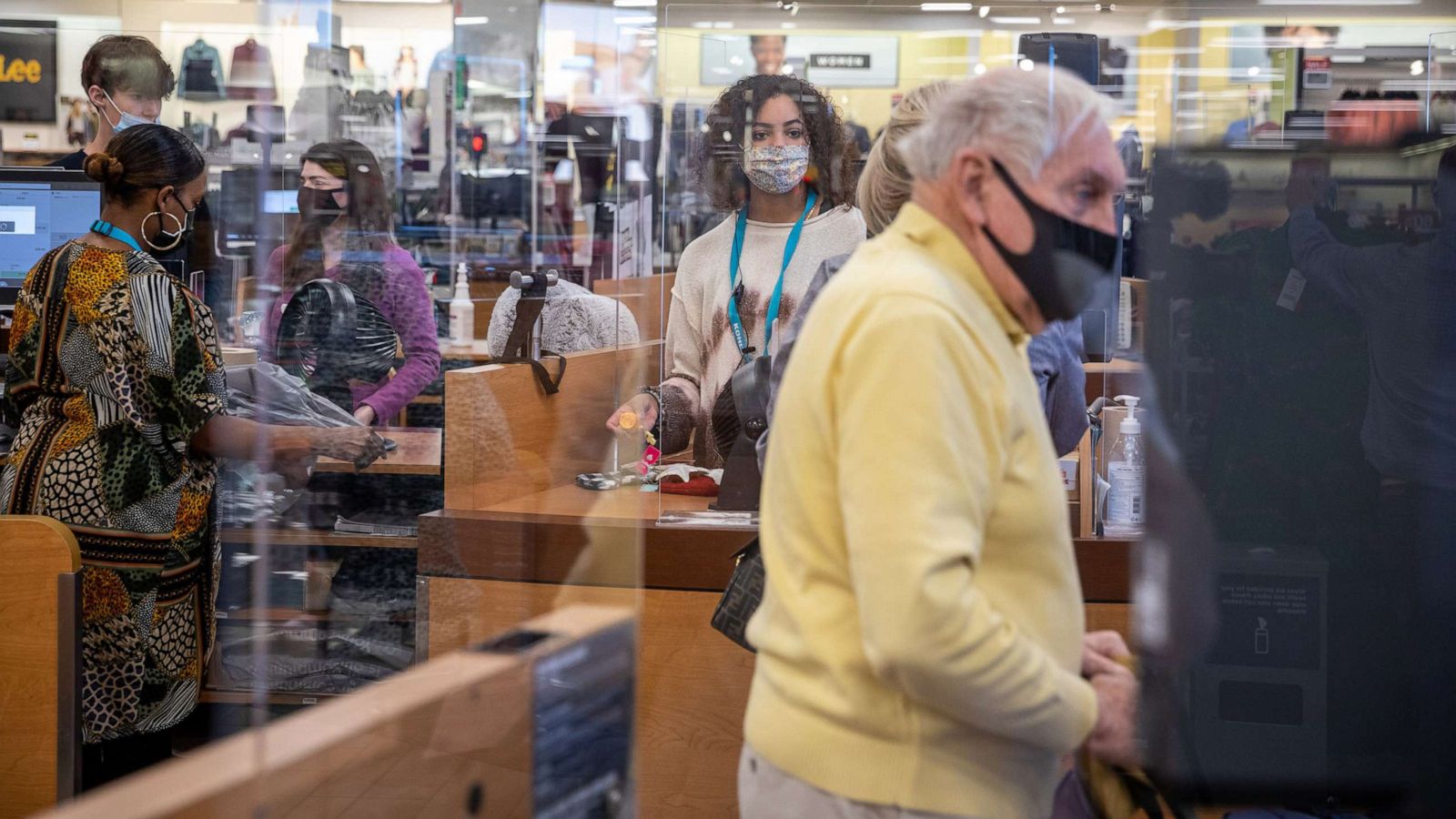 PHOTO: Employees wearing protective masks assist customers at the checkout counter at a Kohl's department store in Woodstock, Ga, Nov. 23, 2020.