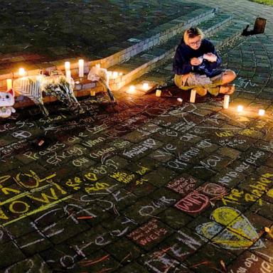 PHOTO: A woman lights a candle during a candlelight vigil at Drake Park for victims of the Silver Rail Elementary School shooting, in Bend, Oregon, October 15, 2026.