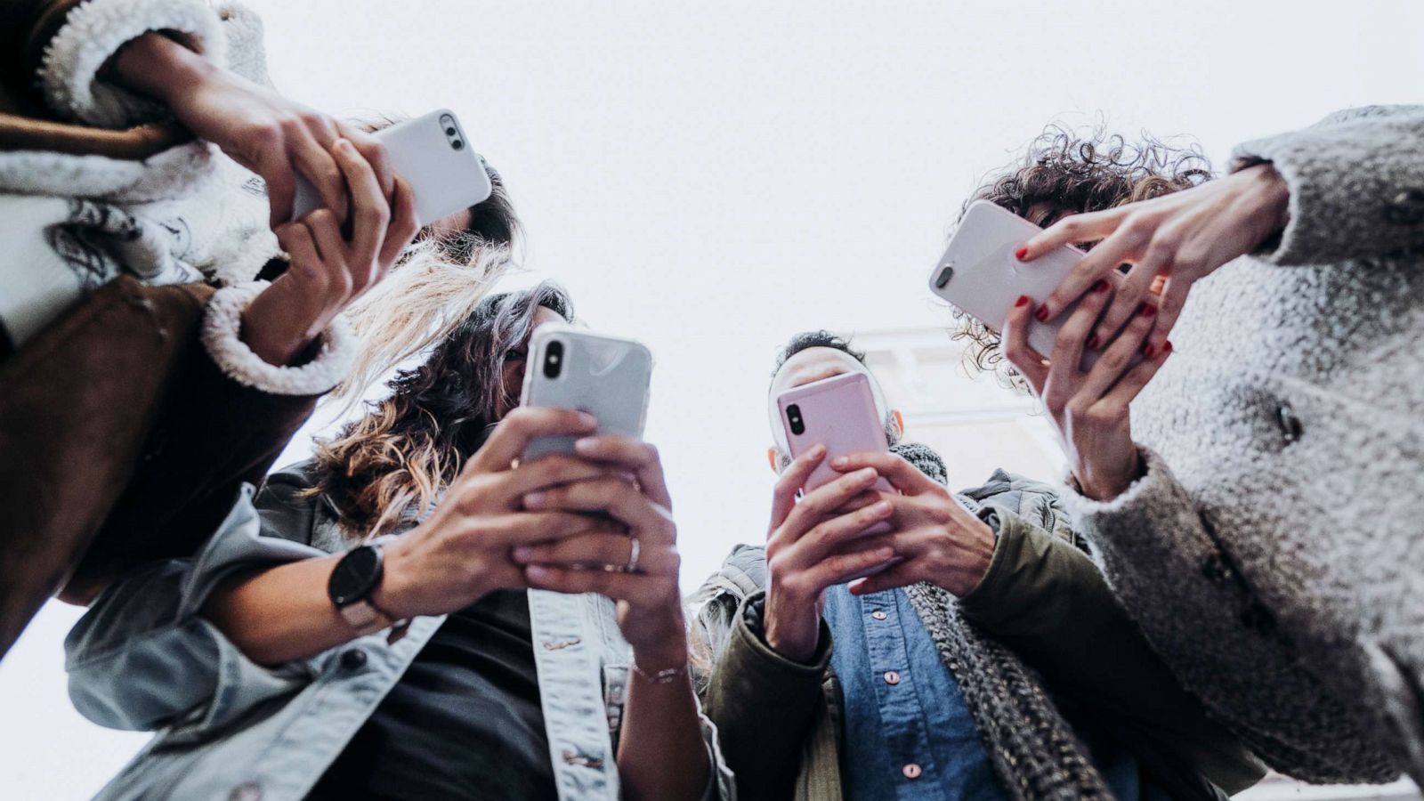 PHOTO: A group of friends use their smartphones.