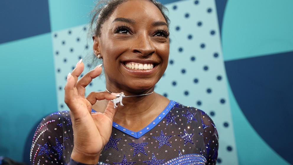 PHOTO: Gold medalist Simone Biles of Team USA poses with a necklace in the likeness of a goat after competing in the Artistic Gymnastics Women's All-Around Final on day six of the Olympic Games Paris 2024, Aug. 1, 2024, in Paris.