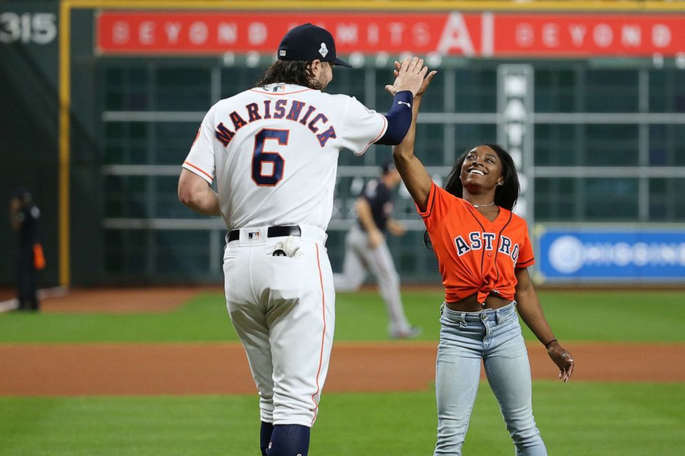 Olympic gymnastics gold medalist Simone Biles high fives Jake Marisnick after throwing out a ceremonial first pitch to Marisnick prior to game two of the 2019 World Series between the Astros and the Washington Nationals at Minute Maid Park, Oct. 23, 2019.