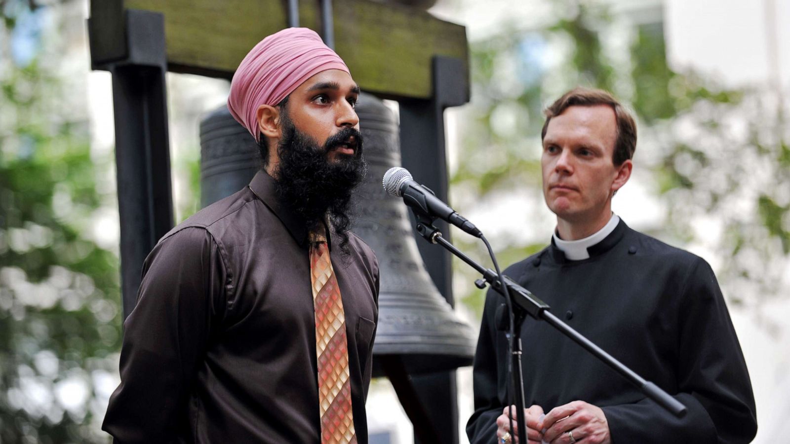 PHOTO: Simran Jeet Singh (left) of the Sikh Coalition speaks as the Reverend Matthew Heyd of Trinity Wall Street listens in the courtyard of St. Paul's Chapel in New York on Aug. 10, 2012.