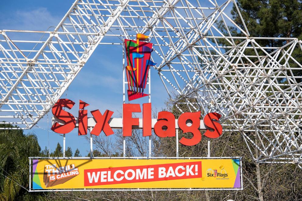 PHOTO: A sign at the entrance of the theme park Six Flags Magic Mountain welcomes the public back on the day of the park's re-opening, April 1, 2021, in Valencia, California.