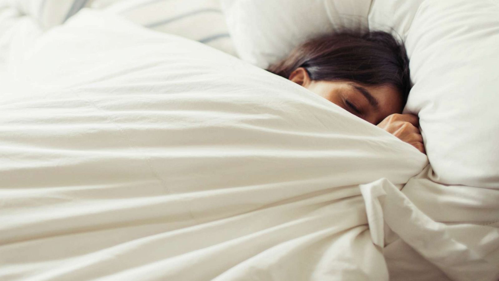 PHOTO: Tired young woman sleeps in bed in this undated stock image.