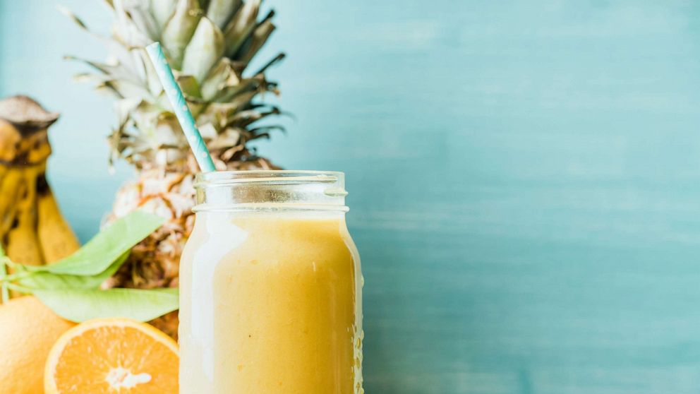 PHOTO: Freshly blended yellow and orange fruit smoothie in glass jar with straw in this undated stock photo.