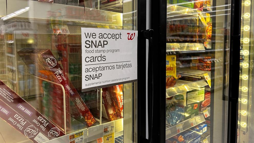 PHOTO: A sign on a door in the frozen food aisle, "We accept SNAP food stamp cards" at a Walgreens in New York, March 30, 2024.