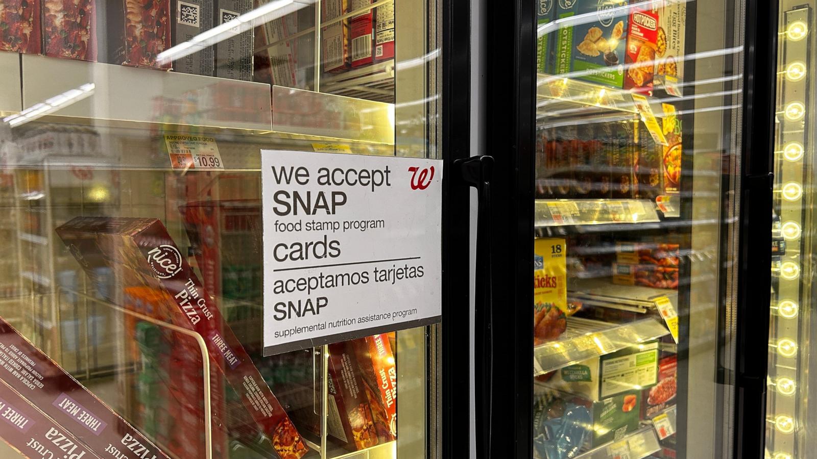 PHOTO: A sign on a door in the frozen food aisle, "We accept SNAP food stamp cards" at a Walgreens in New York, March 30, 2024.