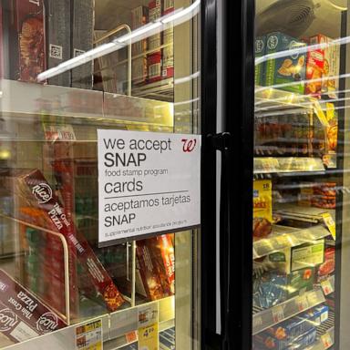 PHOTO: A sign on a door in the frozen food aisle, "We accept SNAP food stamp cards" at a Walgreens in New York, March 30, 2024.